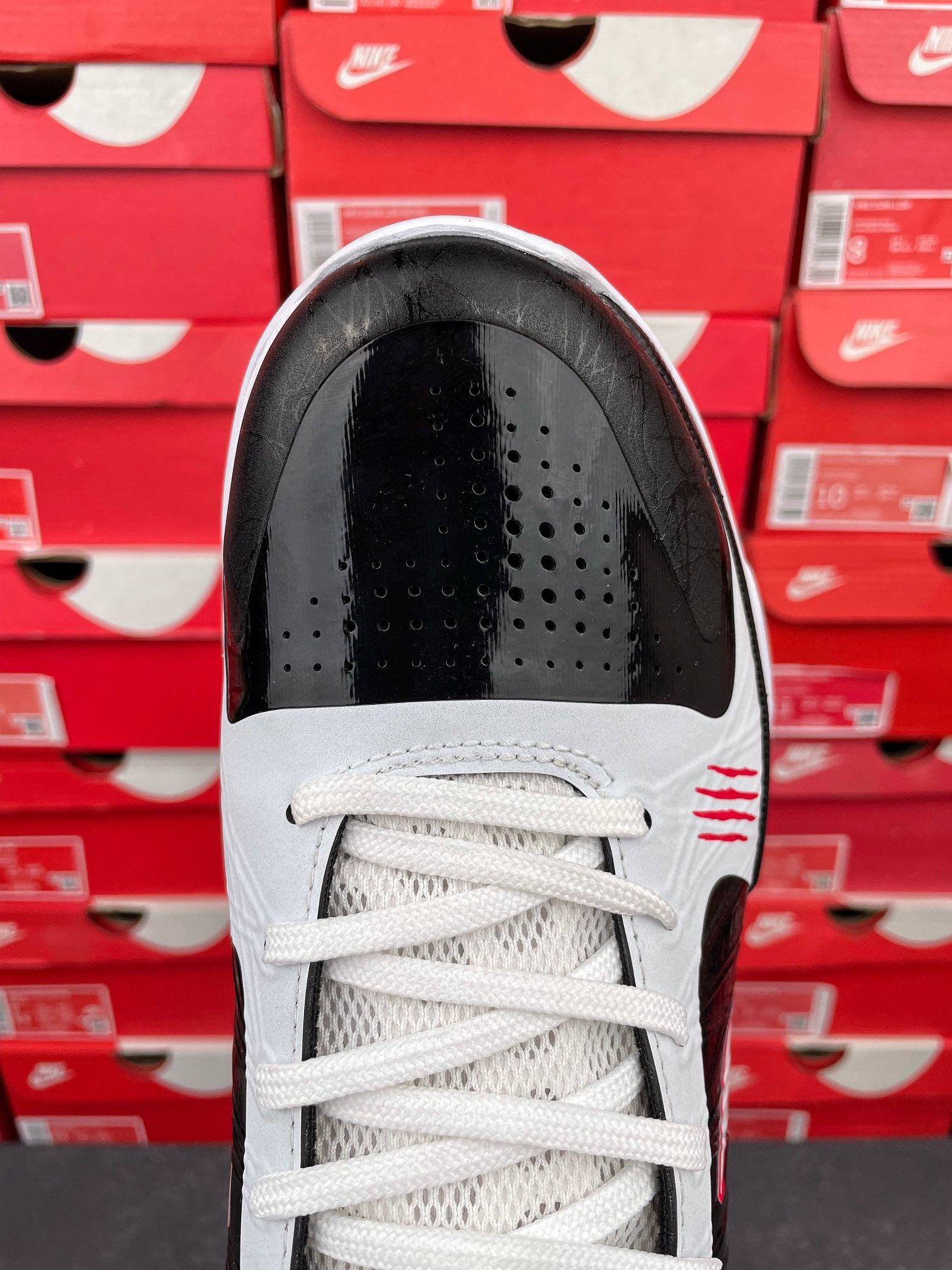 Black and white high-top sneakers with white laces and vented toe cap