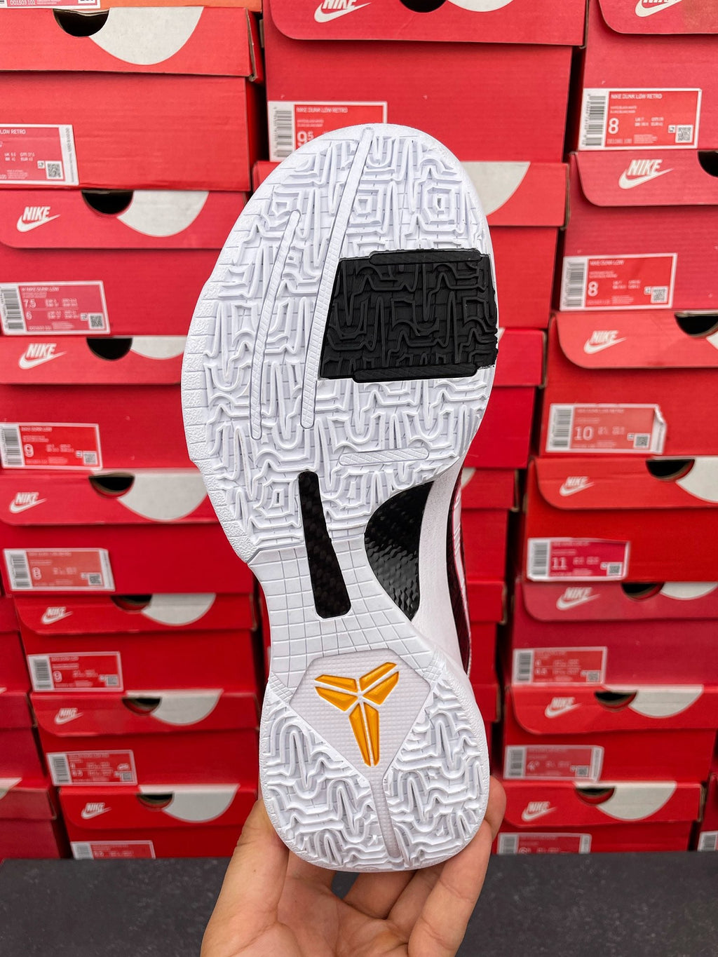 White outsole and black traction insert on basketball sneakers with red heel mark
