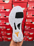White outsole and black traction insert on basketball sneakers with red heel mark