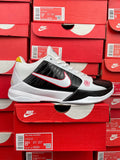 White and black basketball sneakers with red swoosh accents and lace-up front