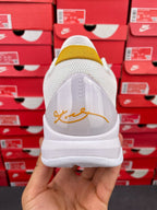 White sneakers with transparent heel panel and yellow sock lining with gold writing