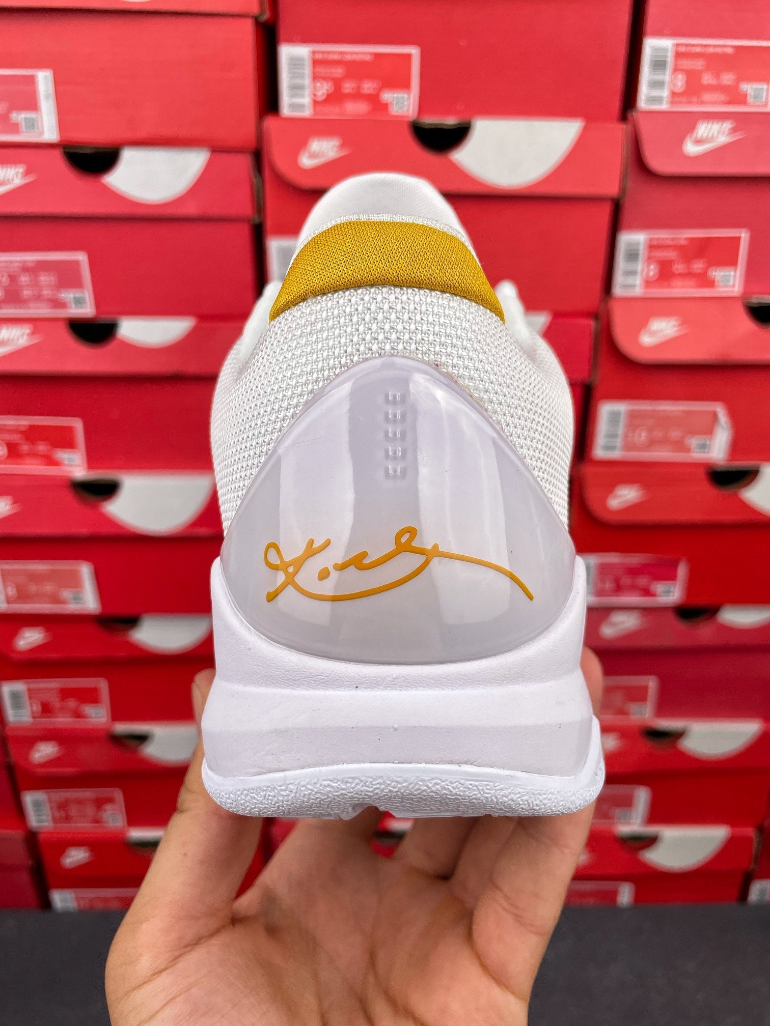 White sneakers with transparent heel panel and yellow sock lining with gold writing