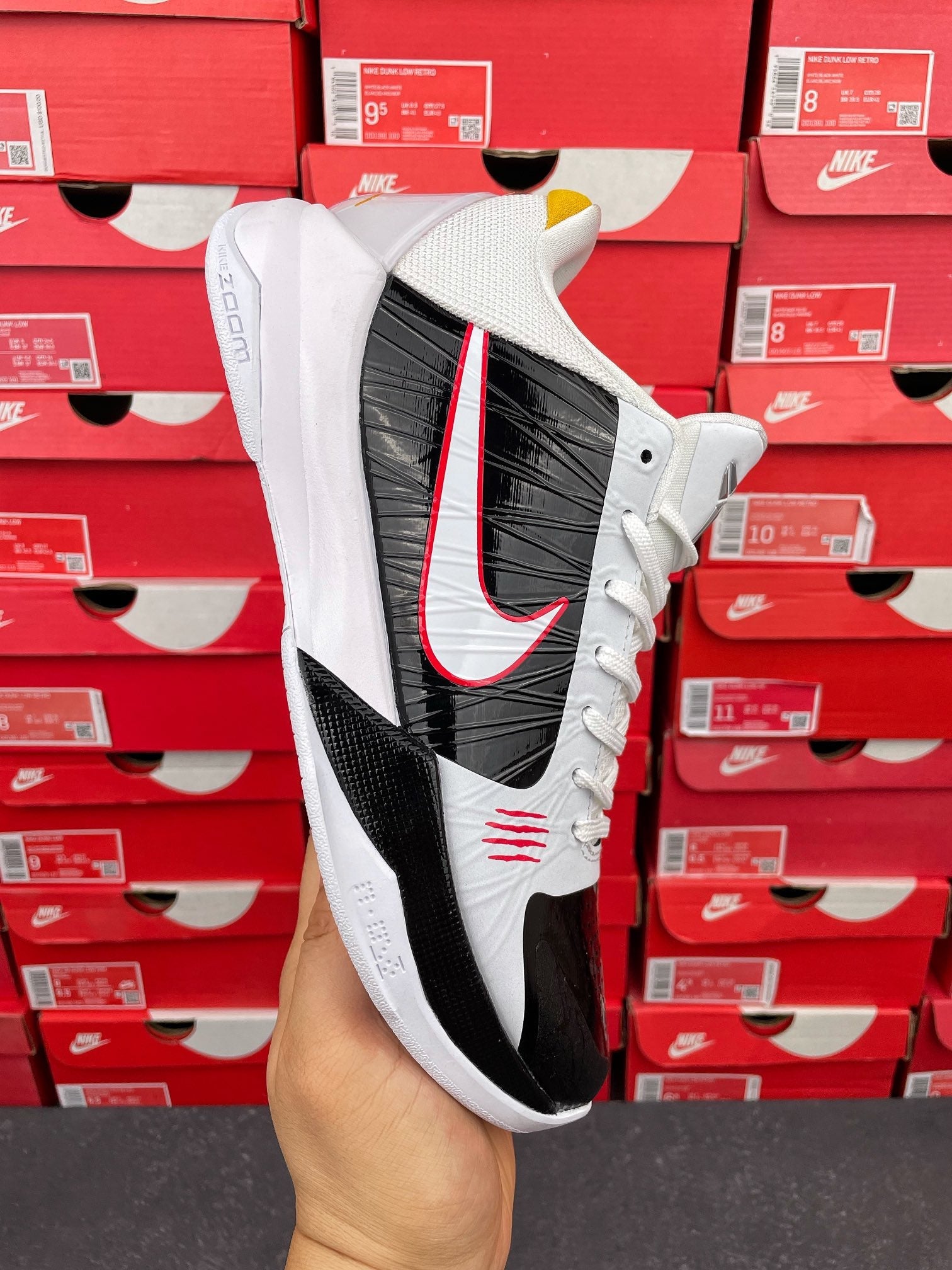 White and black high-top sneakers with red swoosh and black side panel