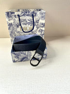 Dior belt laid out with dark blue strap and black buckle over textured leather