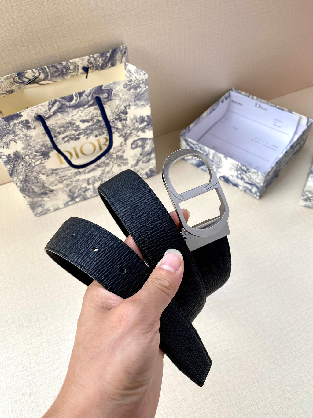 Dior belt with dark blue strap, silver-toned buckle hardware, and visible holes