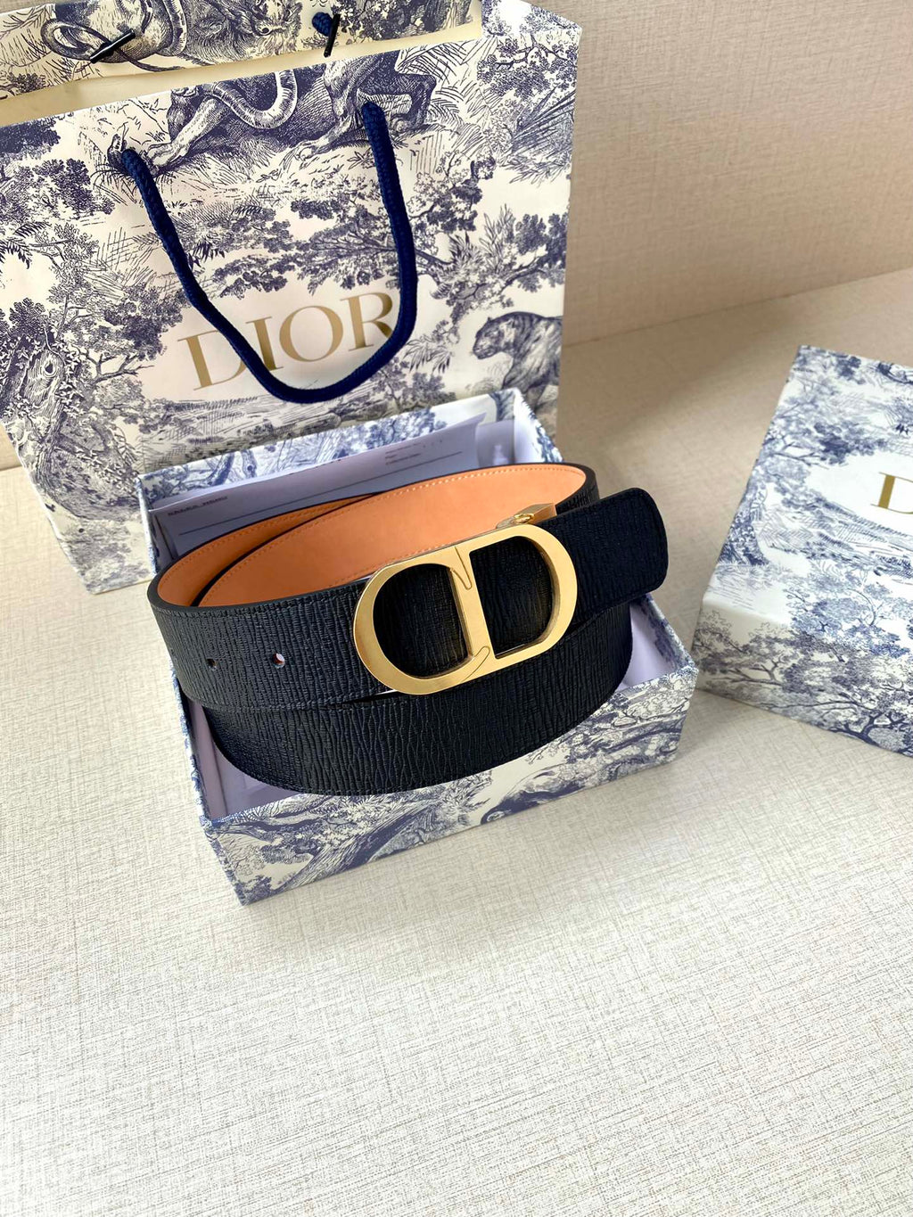 Dior belt dark navy strap with gold buckle, shown on box