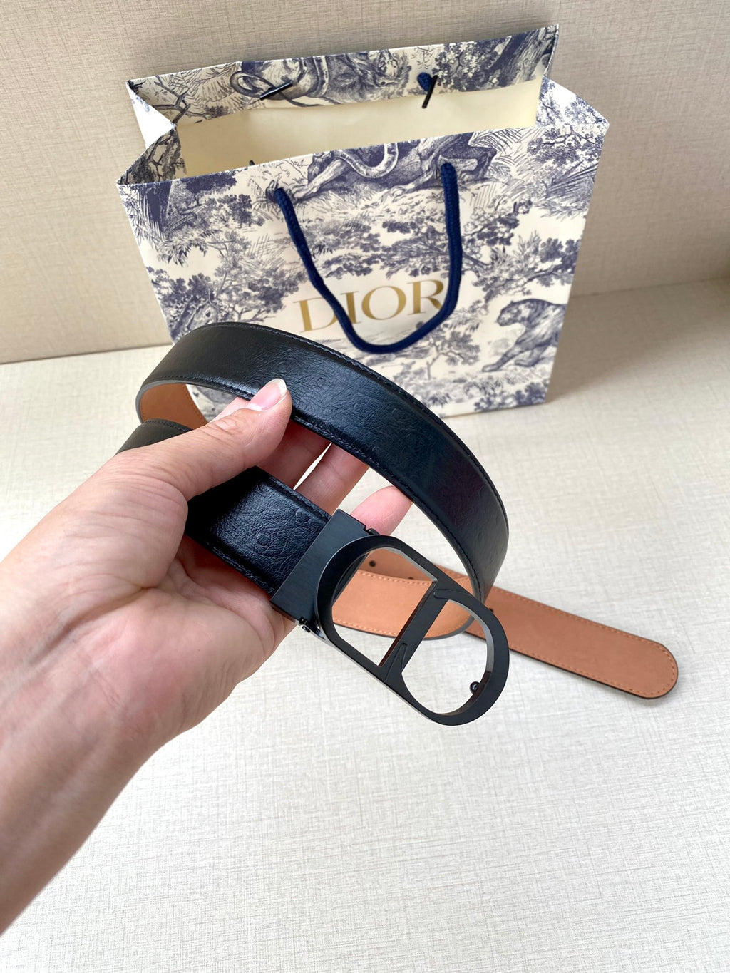 Dior belt underside view: black outer strap with tan lining and black buckle