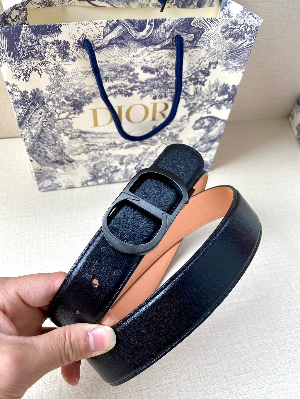 Dior belt detail: black strap with tan lining and gold-tone buckle