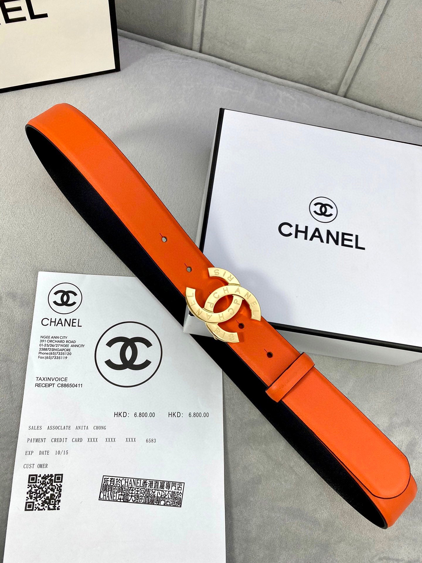 Orange belt with gold CC buckle, black underside and metal prong detail