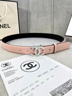 Pink leather belt with gold-tone double-ring logo buckle and punched holes.
