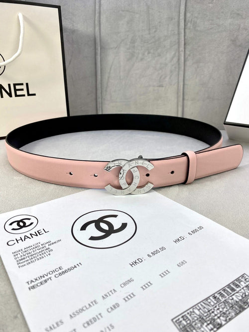 Pink leather belt with gold-tone double-ring logo buckle and punched holes.