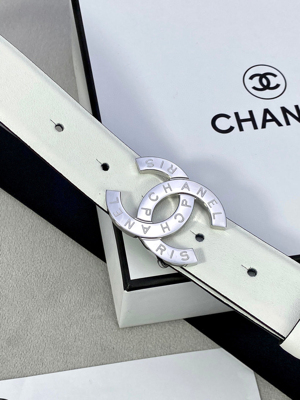Chanel belt in pale white leather with silver-toned CC buckle and eyelet holes