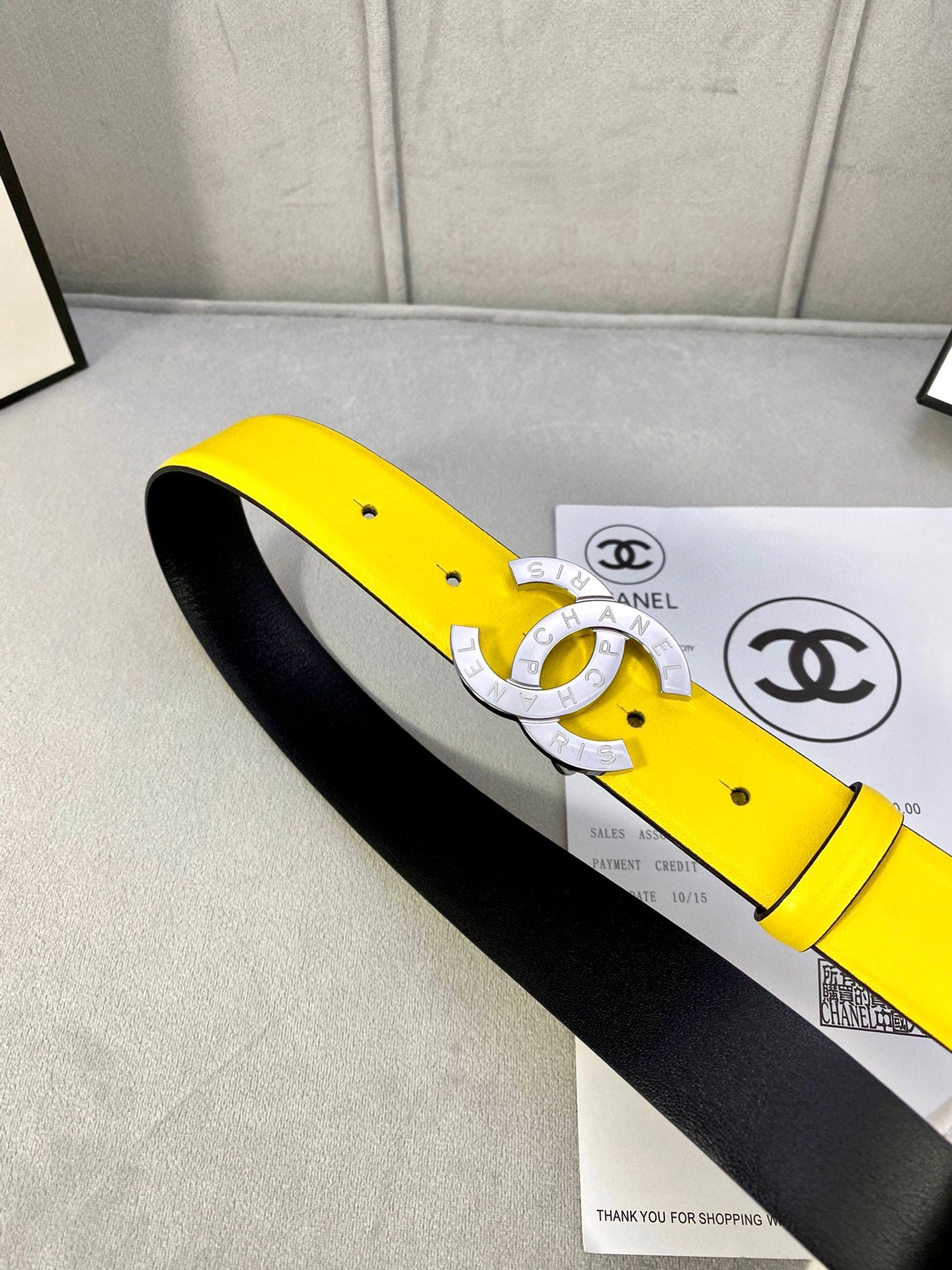 Yellow leather belt with gold-tone CC buckle and black underside on box