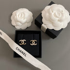 Gold-tone CC stud earrings with rhinestones, displayed in black box