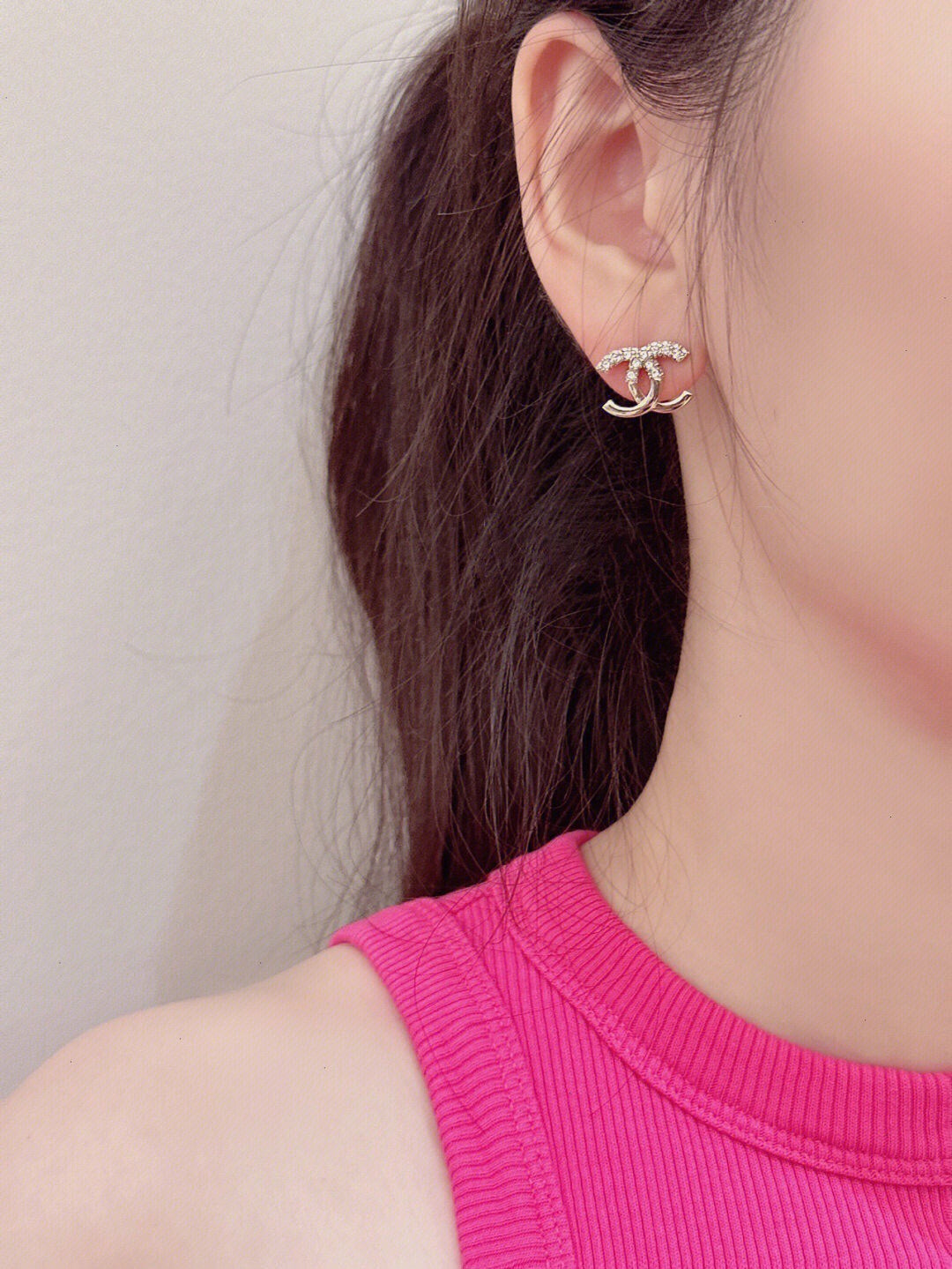 Silver-tone CC hoop earrings with rhinestone details on ear