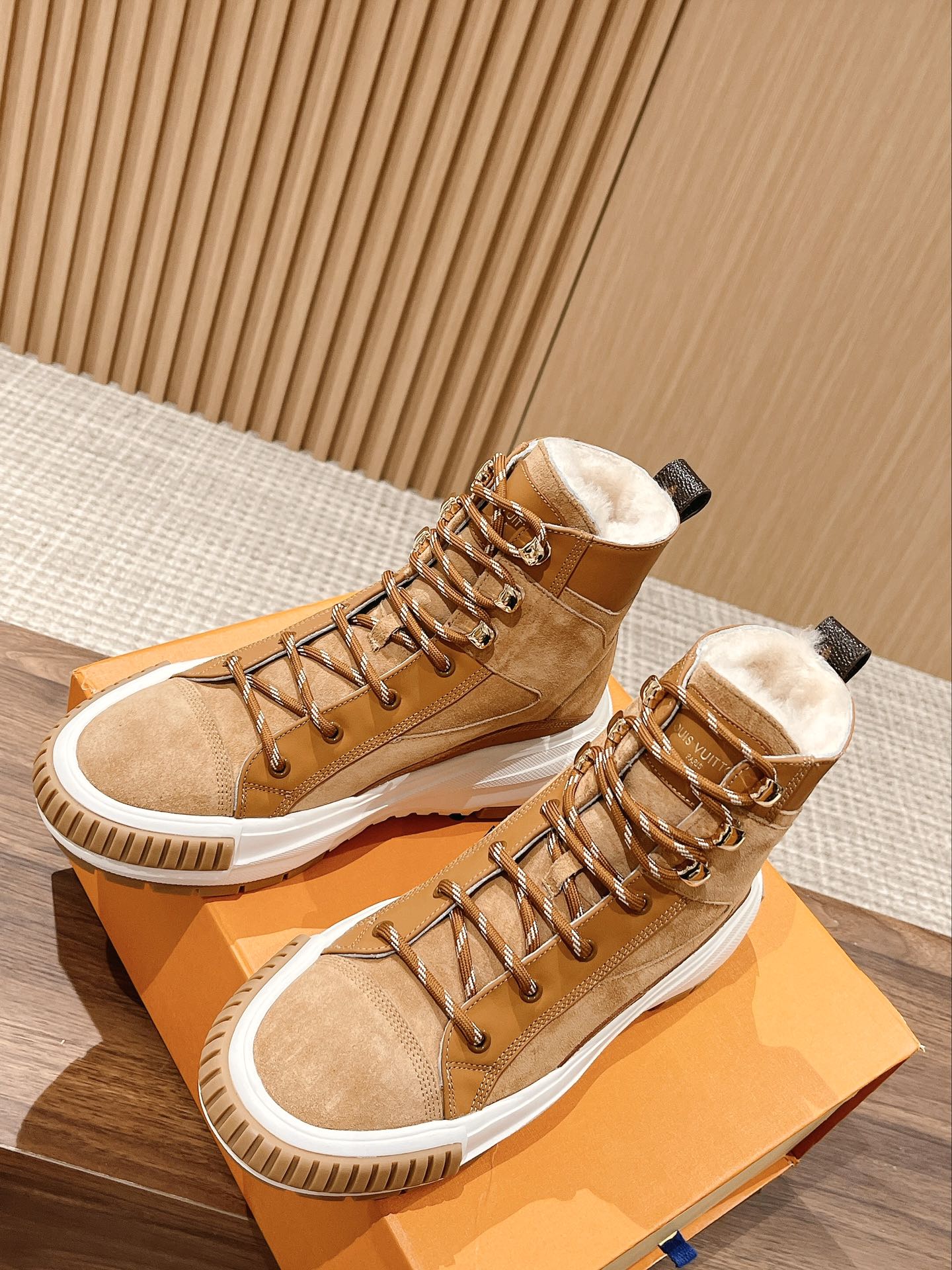 Tan and brown Louis Vuitton high-top sneakers with fur lining, white soles, and lace-up