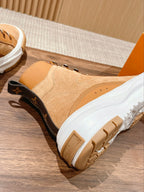 Tan Louis Vuitton high-top sneaker with black heel patch, white sole, and lace-up design