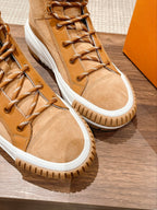 Pair of tan Louis Vuitton high-top sneakers with lace-up front and white rubber soles