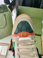 Gucci unisex sneaker toe with green monogram pattern and orange trim