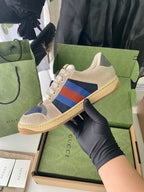 Cream suede sneakers with Gucci multicolor stripe and blue heel, lace-up style.