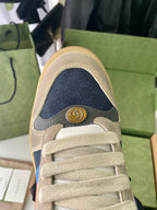 Cream suede sneakers toe view with Gucci logo plaque on heel collar.