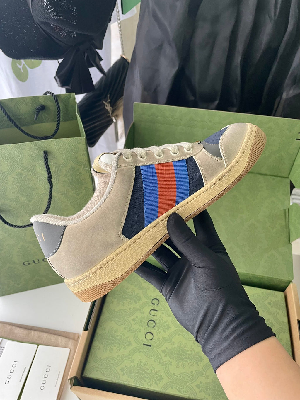 Cream suede low-top sneakers with multicolor stripe on side and tan sole.