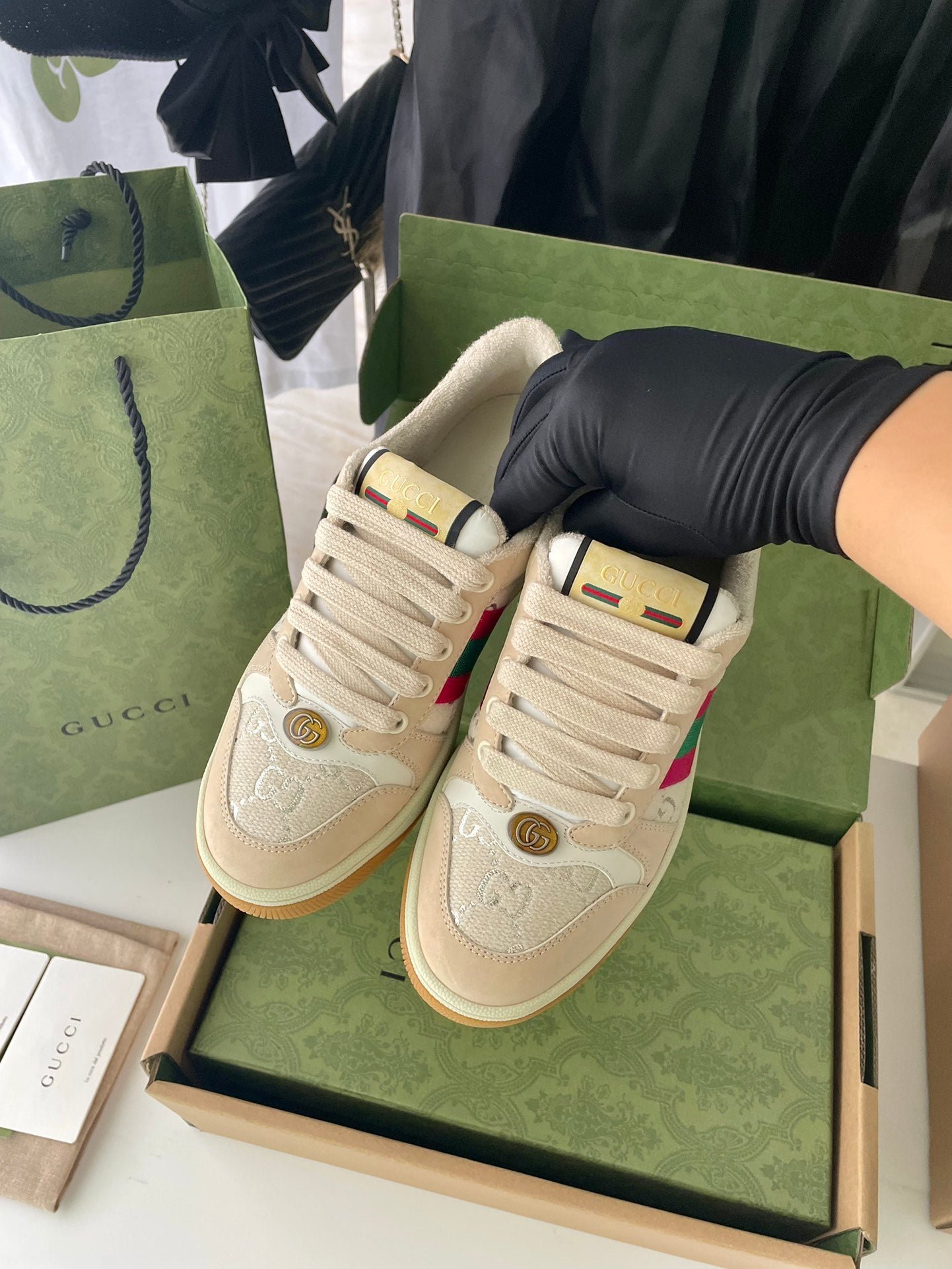 Pair of beige lace-up low-top sneakers with colorful stripe and tan rubber sole