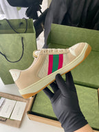 Beige lace-up low-top sneaker with multicolor side stripe and tan rubber outsole