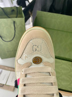 Beige sneaker close-up of lace area with embossed emblem and trim stitching