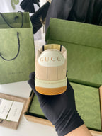 Beige sneaker heel with GUCCI logo patch and tan textured rubber sole