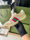 Beige lace-up low-top sneaker with colorful stripe detail on the side and tan sole