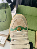 Beige sneaker toe cap with GG logo pattern, green trim, and lace-up front.
