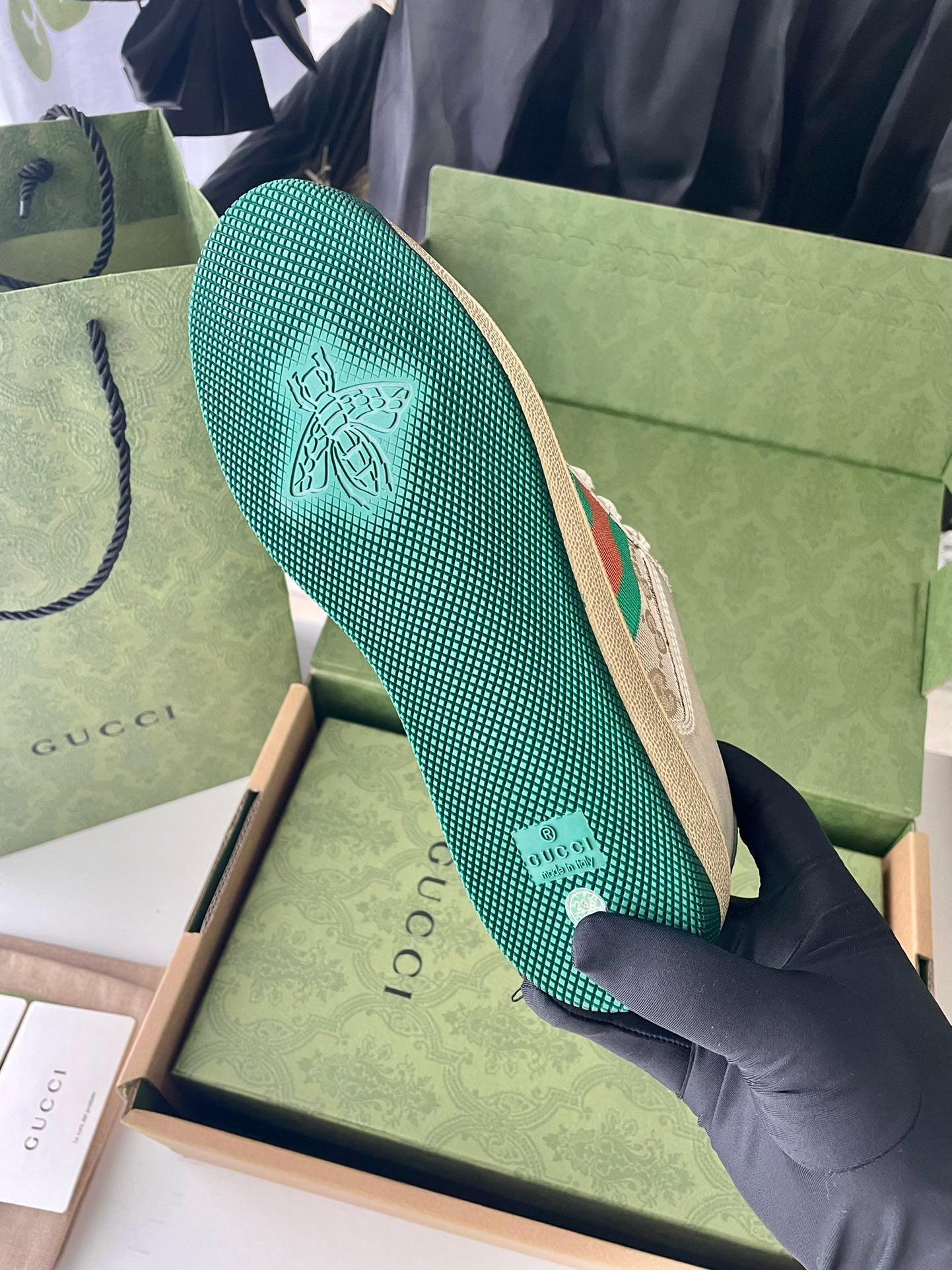 Green patterned sneaker outsole with embossed logo and treaded texture.