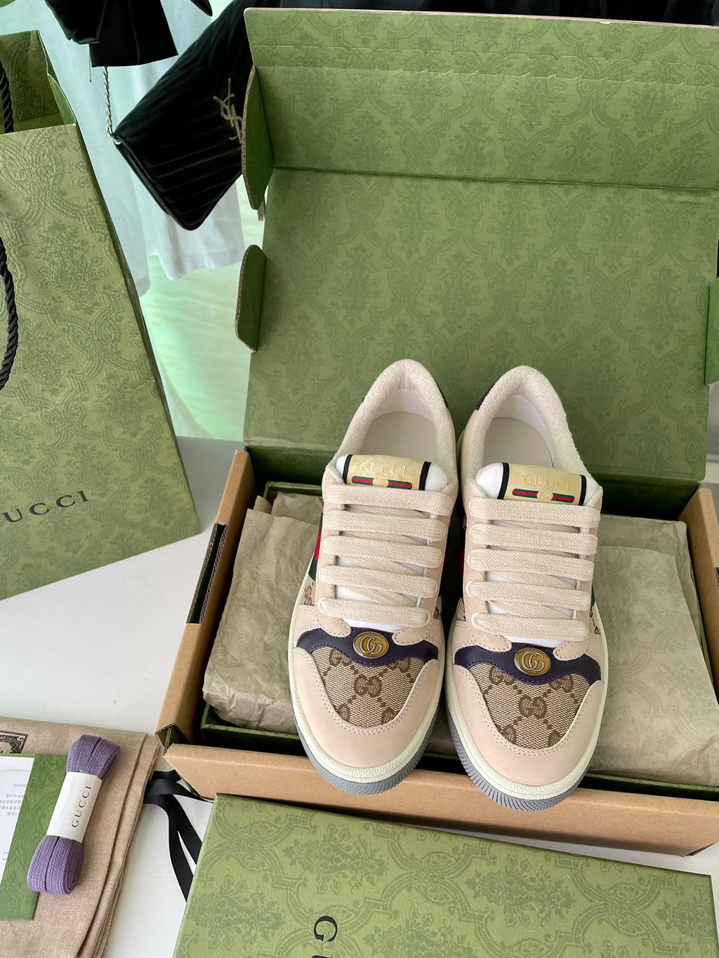 Gucci sneakers pair with beige GG canvas, red/green Web stripe, lace-up fronts.
