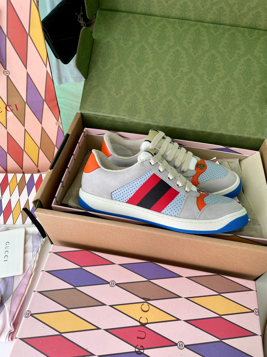 Gucci unisex sneakers front view, light gray leather with red and navy stripe and blue sole