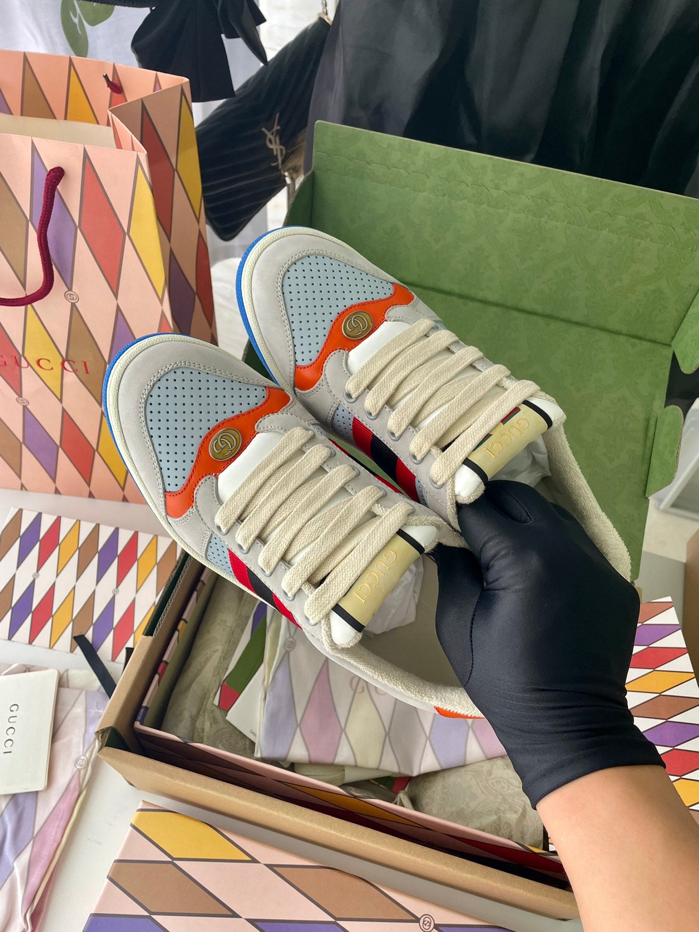 Gucci unisex sneakers pair side view, light gray uppers with multicolor stripe and blue sole