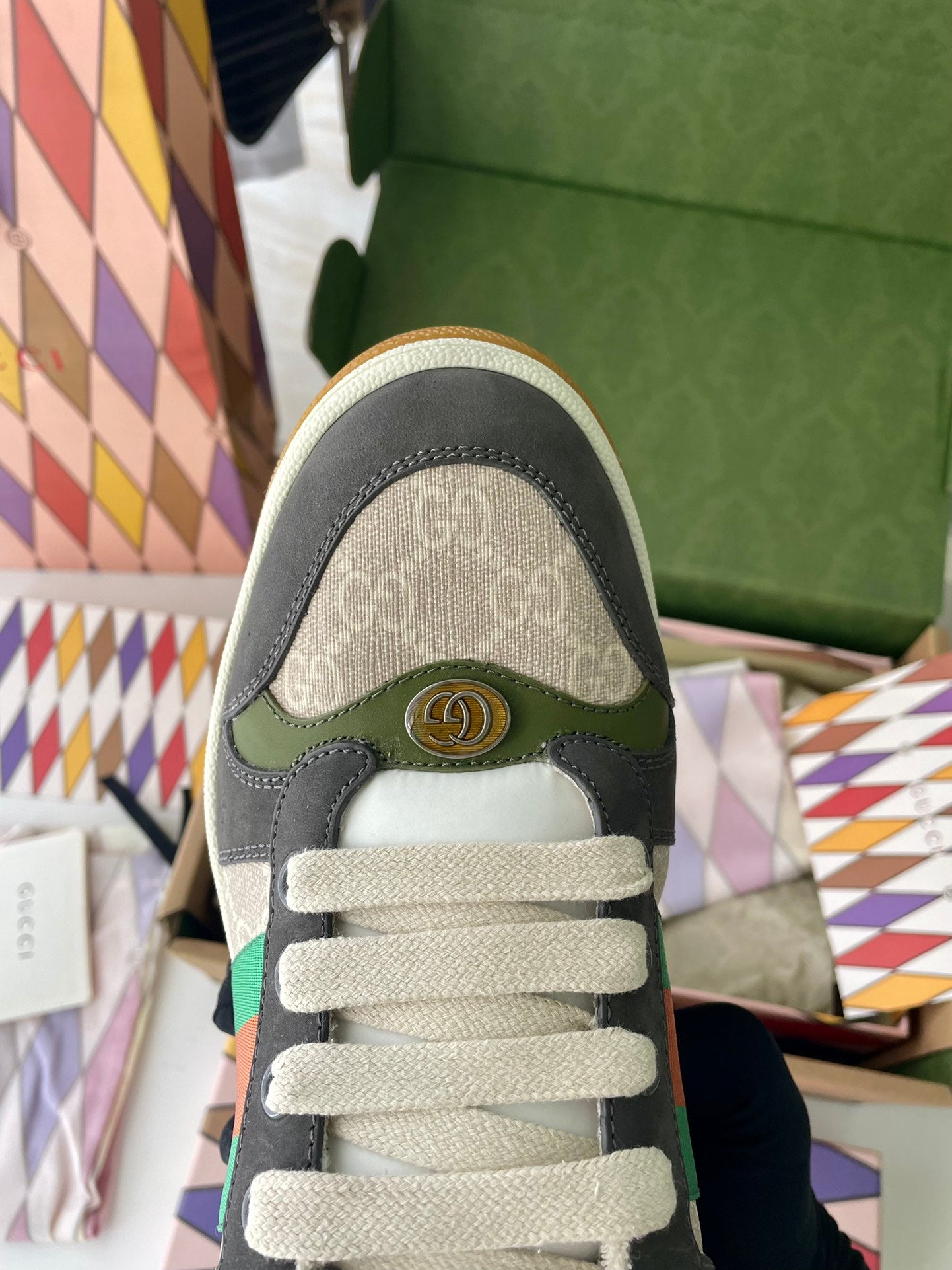 Gucci unisex sneaker toe and laces view: dark gray and green with beige web trim.