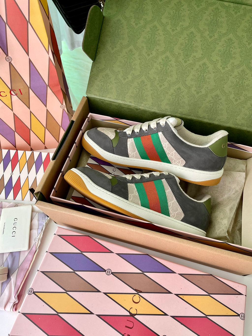 Gucci unisex low-top sneakers in box: dark gray with green/red stripe and cream sole.
