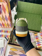 Gucci unisex sneakers heel view with green logo patch, dark gray suede, white rubber sole.