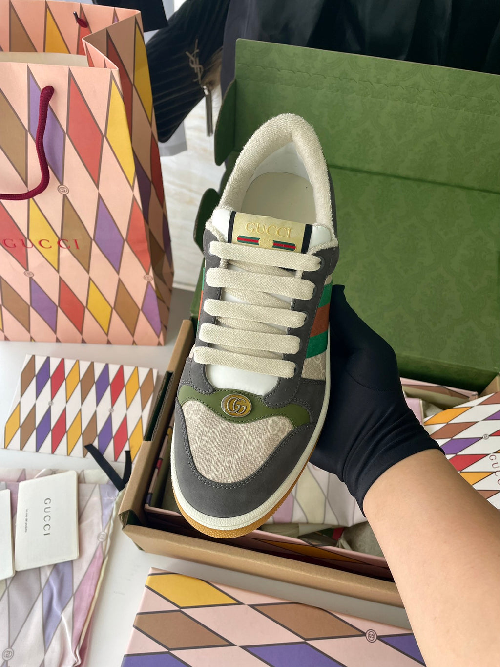 Gucci unisex low-top sneakers, side view: dark gray suede, white laces, green stripe.