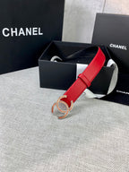 Red leather belt with gold-tone CC logo buckle resting in a gift box