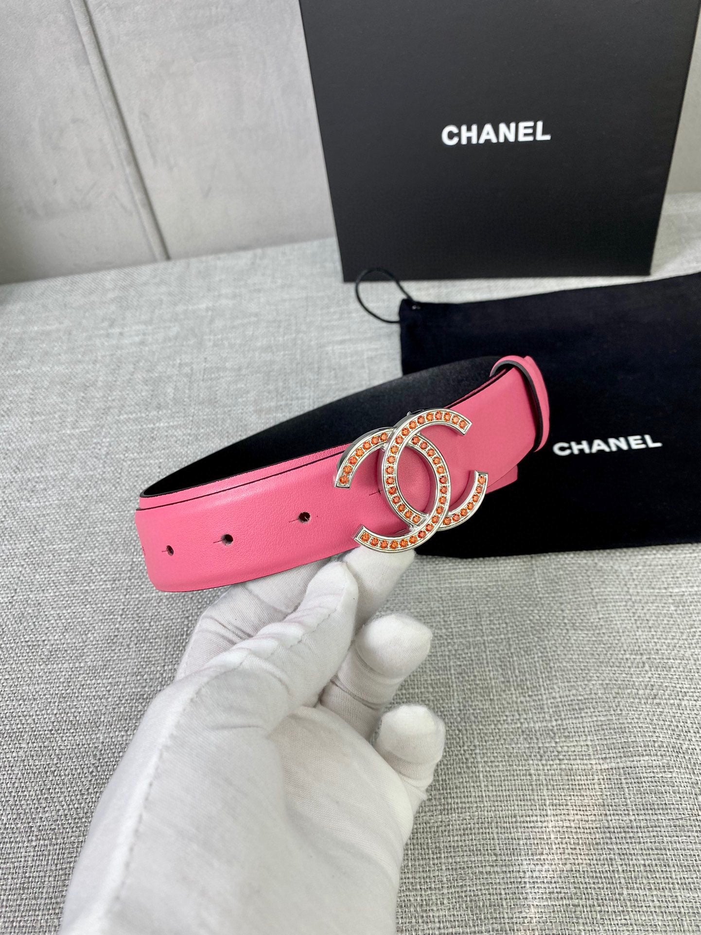 Pink leather belt with gold-tone CC buckle, strap side with punched holes