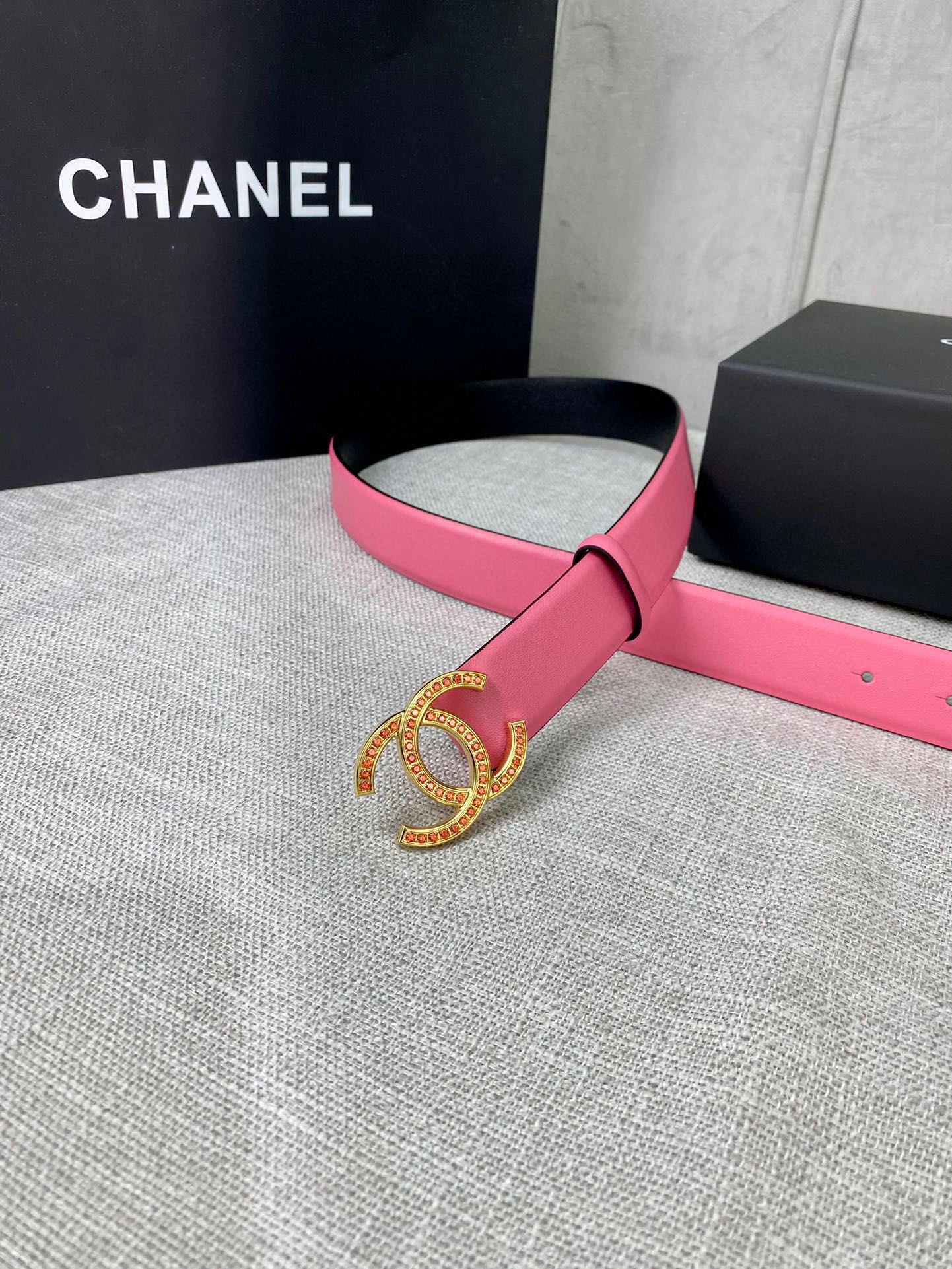 Pink leather belt with gold-tone CC buckle, looped on display