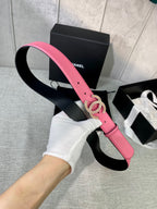 Pink leather belt with gold-tone CC buckle held with hand and white glove