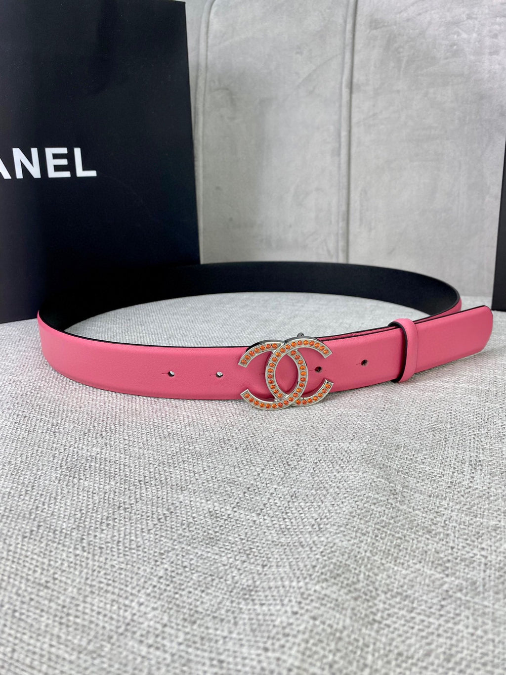 Pink leather belt with gold-tone CC buckle and gold studs along the strap
