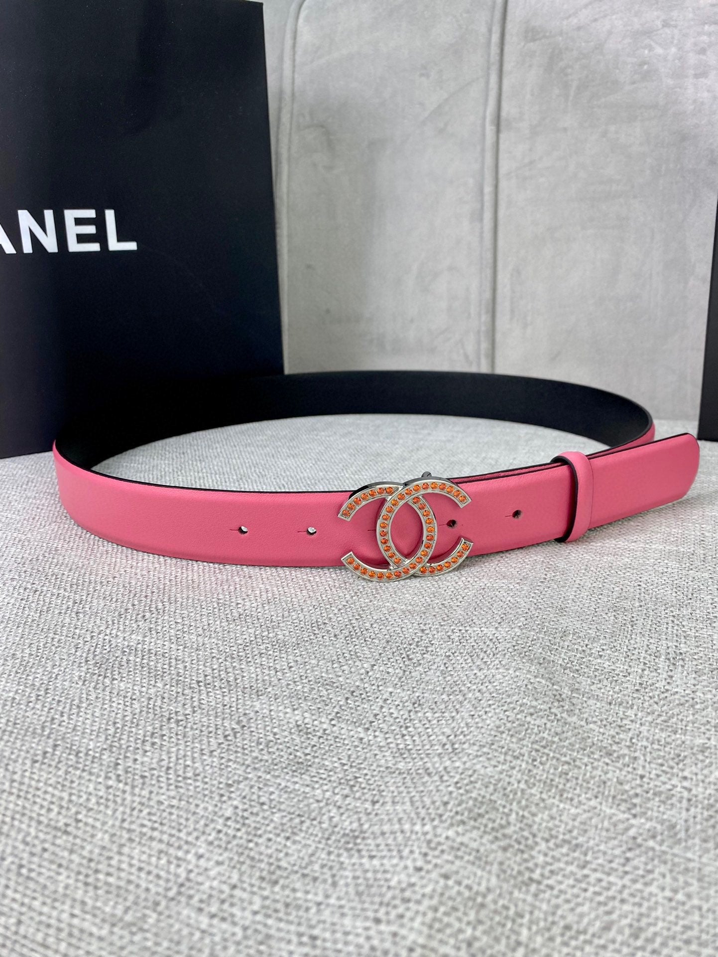 Pink leather belt with gold-tone CC buckle and gold studs along the strap