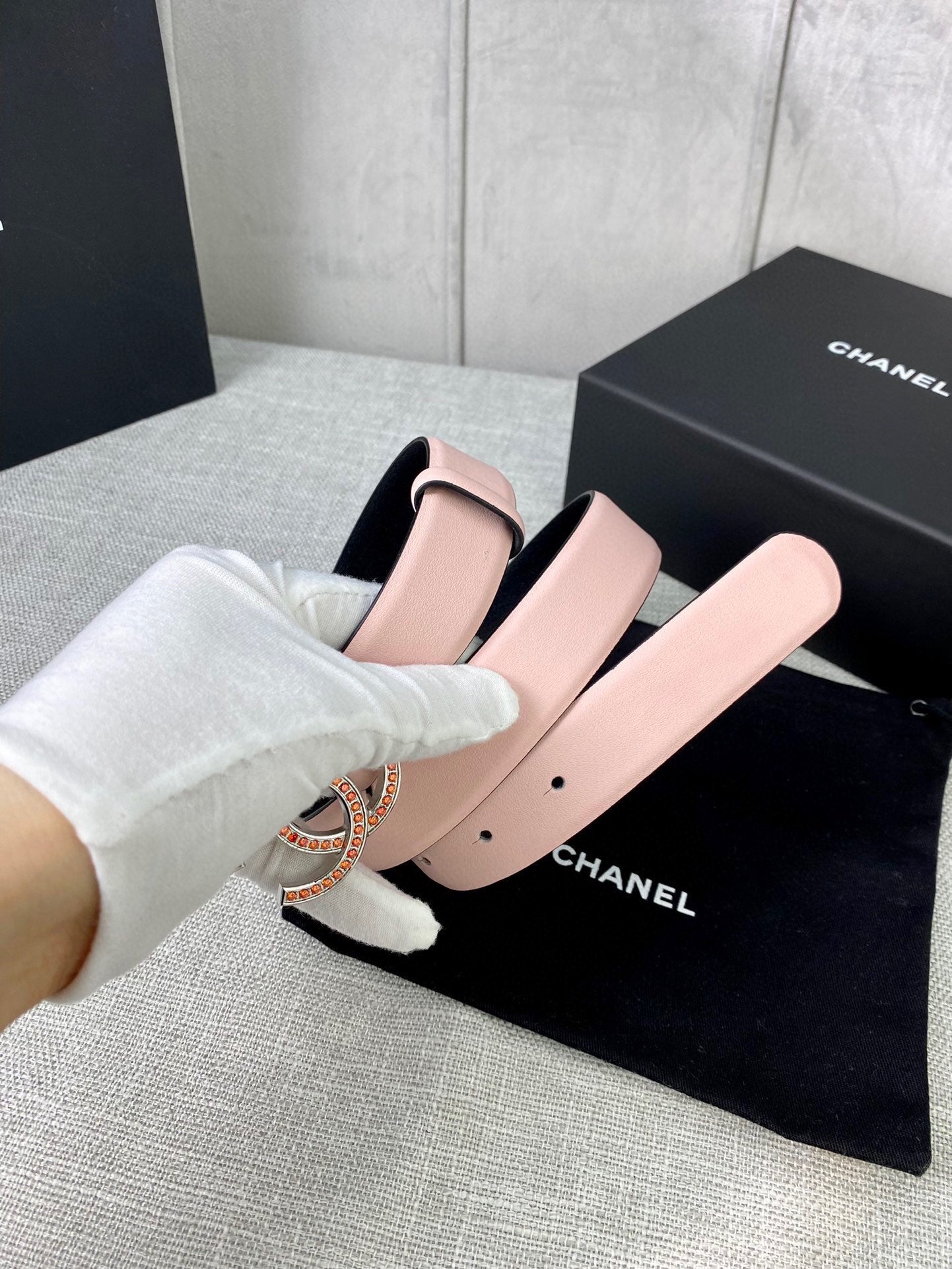 Light pink leather belt with gold logo buckle, worn look with white gloves