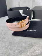 Light pink leather belt with gold logo buckle on black pouch inside box