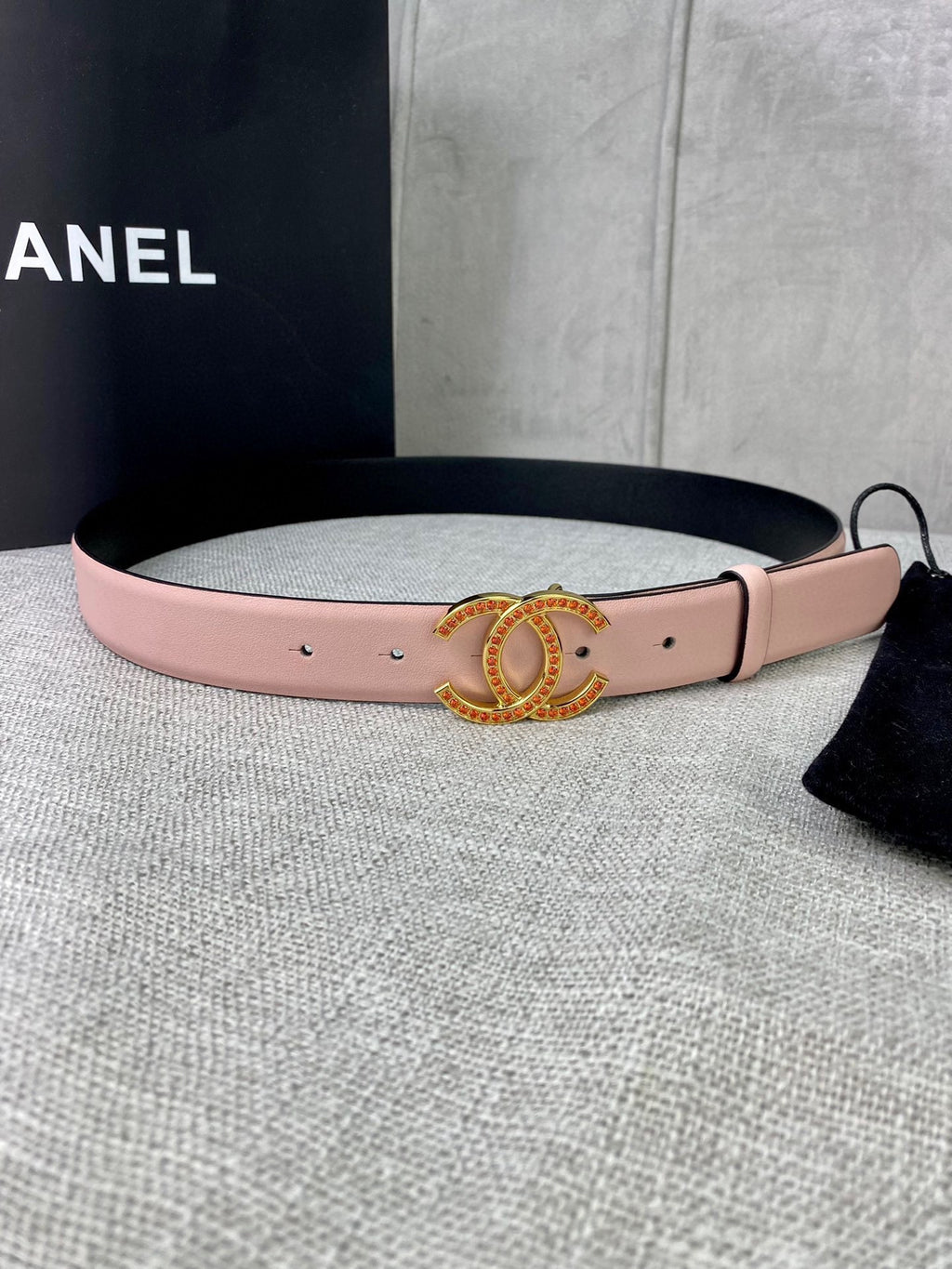 Light pink leather belt with gold logo buckle and rhinestone border