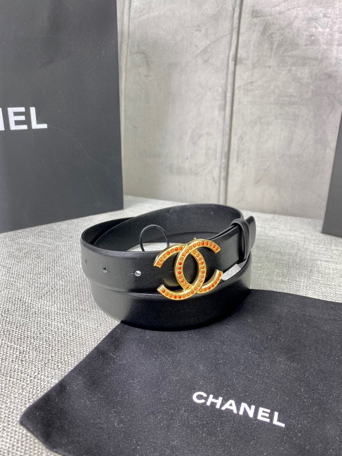 Black leather belt with jeweled CC buckle on display surface